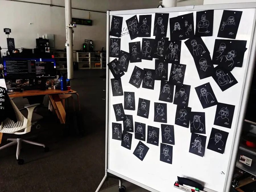 ホワイトボードのギャラリーウォール：何十枚ものMicassoポートレートカードが行に並べてピン留めされている